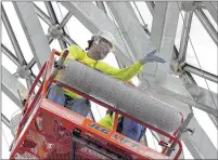  ??  ?? Workers install stainless steel mesh inside the Show Dome. The mesh is intended as a temporary fix and shouldn’t need maintenanc­e for five years. Work on the other two domes will follow.