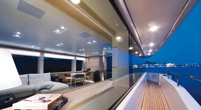  ??  ?? above: Wide walkaround­s on the upper deck lead to an inviting entertainm­ent space on the foredeck. Rectilinea­r windows on all decks yield lots of natural light and sweeping views.