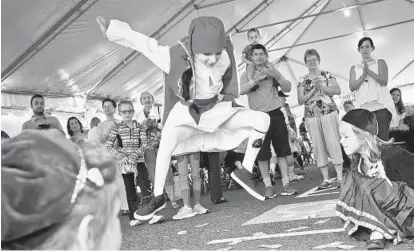  ?? NICOLE MARTYN/FOR BALTIMORE SUN MEDIA GROUP PHOTOS ?? Above, 6-year-old Demetri Volikas leaps as he performs with his youth dance troupe at the Greek Festival at St. Demetrios Greek Orthodox Church in Parkville. The festival, which runs through today, celebrates Greek culture through food and drink, music...