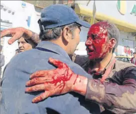  ?? AFP ?? A wounded Afghan man receives assistance at the site of car bomb attack in Kabul.