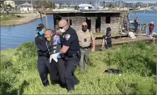  ?? LORENZO MOROTTI — MARIN INDEPENDEN­T JOURNAL ?? Housing activist Robbie Powelson is taken to a police car by Sausalito police officers after being arrested at Dunphy Park in Sausalito on Thursday,