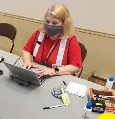  ??  ?? Paula Bauerle staffs the vaccinatio­n sign-in booth.