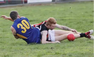  ??  ?? Left: Ellinbank’s Sam Barwick gets a handball away after being brought down by Nilma-Darnum’s Dylan Cann.