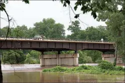  ?? Staff photo by Evan Lewis ?? The Red River continues to rise Thursday under the southbound side of the Index Bridge on U.S. Highway 71. As of press time Thursday night, the bridge remained open. The water there is expected to swell into a major flood around Saturday night and into...