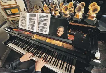  ?? Mel Melcon Los Angeles Times ?? DAVID FOSTER is ref lected in a piano — home to a crowd of his Grammy trophies — at his Westwood condo.