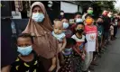  ?? Photograph: Willy Kurniawan/ ?? People queue to receive government assistance in Jakarta, Indonesia. The country reported 56,000 new Covid cases on Thursday.