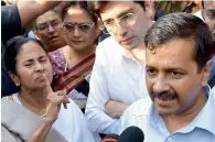  ?? PTI ?? Mamata Banerjee and Arvind Kejriwal talking to media during a sit-in in front of Reserve Bank of India in New Delhi. —