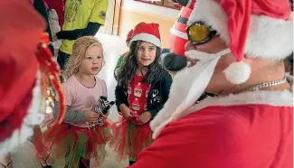  ?? PHOTO: WARWICK SMITH/FAIRFAX NZ ?? Georgie Adlam, 4, and Sophia Mckenzie, 5, meet Shannon’s Father Christmas.