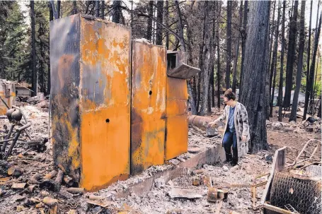  ?? MASON TRINCA/THE WASHINGTON POST ?? Brenda Russell searches through her family’s burned belongings in what had been their garage.