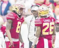  ?? MARK WALLHEISER/AP ?? FSU coach Willie Taggart talks with defensive backs Stanford Samuels III (8) and Asante Samuel Jr. during the 2018 season.