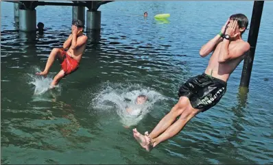  ?? HEINZ-PETER BADER / REUTERS ?? Boys jump into the water at the Alte Donau, a former branch of Danube river, in Vienna, Austria, on Monday, as sweltering weather gripped much of Europe.