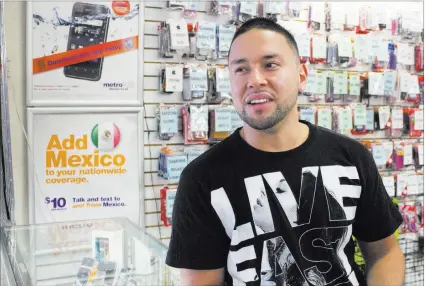  ?? PHOTOS BY ANDREA CORRAL/ LAS VEGAS REVIEW-JOURNAL ?? Donald Perez helps out in his mother’s store selling cellphones and accessorie­s at Bonanza Indoor Swap Meet.