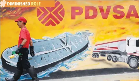  ?? — Reuters ?? A worker walks past a mural with a PDVSA logo at its gas station in Caracas, Venezuela.