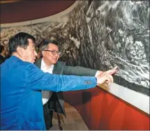  ??  ?? Liu Dawei (front), chairman of the China Artists Associatio­n, who participat­ed in the painting project, exchanges ideas with the director of the National Museum of China, Wang Chunfa, about the scroll at the exhibition.