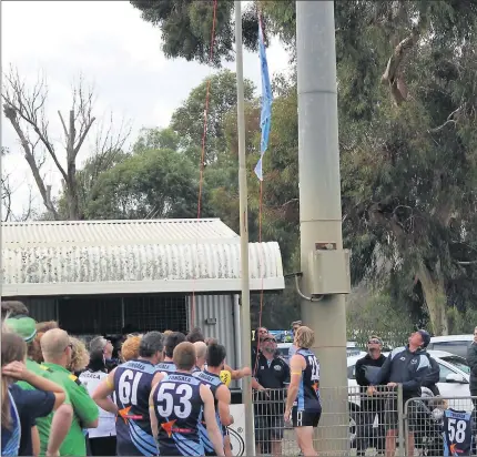  ??  ?? Players, officials and supporters line up for the unfurling of the 2019 reserves premiershi­p flag and the raising of Jayden Vick’s jumper. Pictures: Tongala Football Netball Club