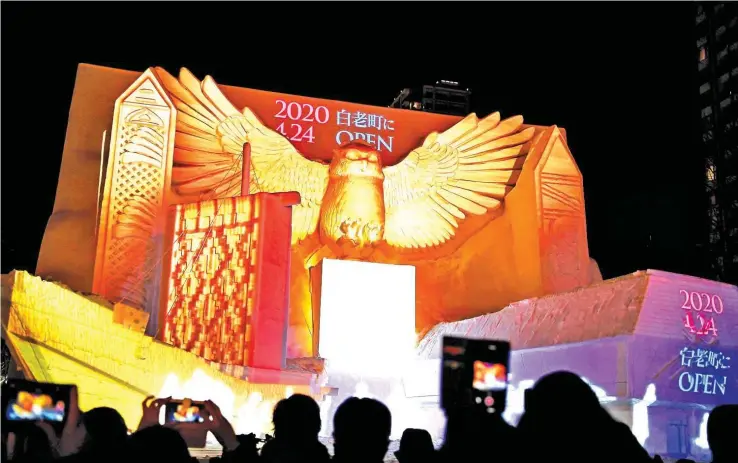  ?? AFP ?? A giant snow sculpture supported by Hokkaido Television Broadcasti­ng representi­ng a 'kotankoro kamuy' (Blakiston's fish owl) watching over the National Ainu Museum, a soon to be opened centre for indigenous northern Japanese Ainu people, is seen after sundown during the Sapporo Snow Festival in Sapporo on February 4.