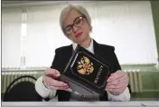  ?? THE ASSOCIATED PRESS ?? An election commission official inspects the passport of a person who came to vote at a polling station, during a presidenti­al election in Makiivka, Russian-controlled Donetsk region, eastern Ukraine, Friday.