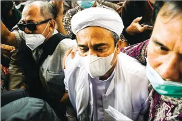  ?? AFP ?? Indonesian Muslim cleric Rizieq Shihab (centre) is surrounded by his supporters on arrival at the police headquarte­rs in Jakarta on Saturday after being summoned.