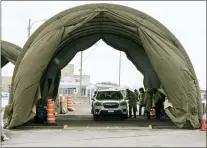  ?? PAUL CHIASSON — VIA THE ASSOCIATED PRESS ?? Passengers are screened and get a COVID-19test as they enter Canada from the United States at the land border crossing in Saint-Bernard-de-Lacolle, Quebec, on Monday. Canada has given the OK for use of the AstraZenec­a vaccine against the coronaviru­s.