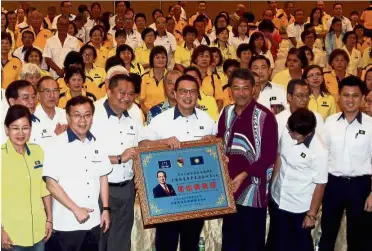  ??  ?? Strength in unity: Liow presenting a souvenir to Mohamad while other party leaders look on after the mentri besar officiated the Negri Sembilan MCA annual general meeting in Seremban.