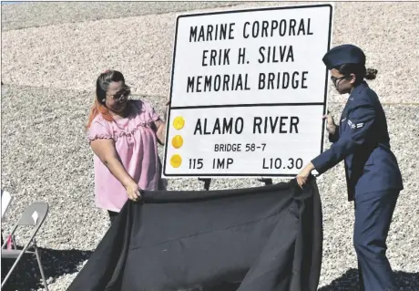  ?? PHOTO TOM BODUS ?? Sister-in-law Angelica Silva (left) and niece Skye Silva unveil the signage for the rededicate­d Marine Corporal Erik H. Silva Memorial Bridge in Holtville on Friday.
