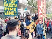  ??  ?? MICHAEL FRANTI sings to protesters. After Nov. 8, San Francisco has undergone the stages of grief, including denial, anger and, later, some acceptance.