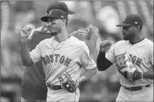  ?? The Associated Press ?? GOLDEN GLOVES: Boston Red Sox right fielder Mookie Betts, front left, and center fielder Jackie Bradley Jr., right, greet teammates after a win over the Detroit Tigers July 22 in Detroit. Betts and Bradley were among the three Red Sox players awarded Golden Glove awards.