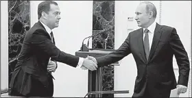  ?? AP/DMITRY ASTAKHOV ?? Russian President Vladimir Putin (right) greets Russian Prime Minister Dmitry Medvedev at a security council meeting Friday in Moscow. Russian officials said the new U.S. sanctions were “an unfriendly act” and vowed to respond with “comparable” harm.