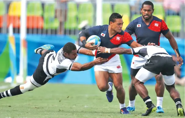  ?? Photo: Rugby World ?? Japan 7s utility Lote Tuqiri against Fiji during the 2016 Olympic Games semi-final in Rio de Janeiro, Brazil. Making the tackle is forward Jasa Veremalua (left). Fiji won 20-7 to later claim the gold medal after beating Great Britain 43-7 in the final.