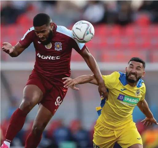  ?? Photos © Domenic Aquilina ?? Gzira ace striker Jefferson Assis (L) preceeds Oscar Carniello (R) of Marsaxlokk to head his team into the lead with a perfectly finished header during the first half.