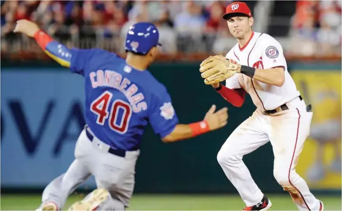  ??  ?? WASHINGTON: Trea Turner #7 of the Washington Nationals forces out Willson Contreras #40 of the Chicago Cubs to start a double play in the seventh inning at Nationals Park on Tuesday in Washington, DC. —AFP