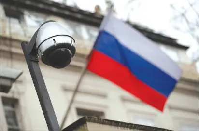  ?? (Hannah McKay/Reuters) ?? A SECURITY camera and a flag flies outside the consular section of Russia’s Embassy in London.