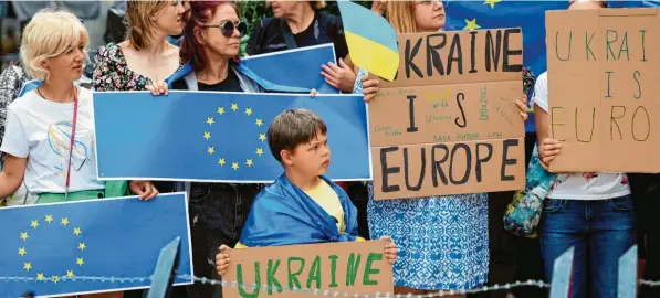  ?? Foto: Olivier Matthys, dpa ?? Eine Gruppe von Bürgerinne­n und Bürgern fordert vor den Gebäuden des Gipfeltref­fens den Beitritt der Ukraine zur EU.