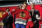  ?? GEORGE WALKER IV — THE ASSOCIATED PRESS ?? Connor Bedard puts on a Chicago Blackhawks jersey after being picked by the team during the first round of the NHL hockey draft on June 28.