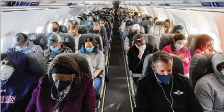  ?? ERIN SCHAFF/THE NEW YORK TIMES ?? Travelers squeeze into a fully booked Jet Blue flight from Ronald Reagan Washington National Airport to Orlando, Fla. More than a million travelers have passed through U.S. security checkpoint­s each day since March 11.