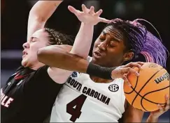  ?? Charlie Neibergall / Associated Press ?? Louisville’s Emily Engstler and South Carolina’s Aliyah Boston go after a loose ball during the first half Friday in Minneapoli­s.