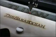  ?? LAUREN HALLIGAN - MEDIANEWS GROUP ?? A freshly engraved piece of wood is completed at Saratoga Custom Engraving.