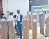  ?? SAKIB ALI/HT PHOTO ?? People wait with empty cylinders at a refilling station in the UPSIDC Industrial Area in Ghaziabad.