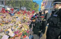  ??  ?? Katie (fourth from left, in pink hijab) with Saima Alvi and her children. Above, police officers pay their respects to the victims of the Manchester bombing