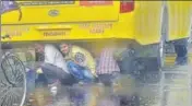  ??  ?? STRUGGLES APLENTY: Migrants taking cover underneath a bus amid downpour in Ludhiana on Thursday. GURPREET SINGH/HT