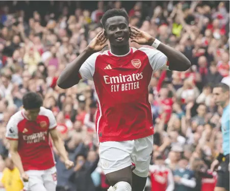  ?? FRANK AUGSTEIN/THE ASSOCIATED PRESS FILES ?? Arsenal's Bukayo Saka celebrates after scoring his side's opening goal in English Premier League action against Bournemout­h in London on Saturday. The Gunners won 3-0 and sit atop the table, one point ahead of Man City, with two games to play.