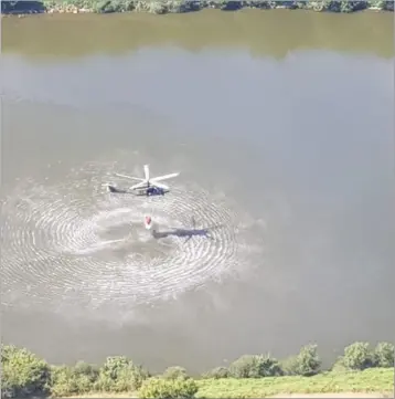  ??  ?? An Air Corps helicopter lifting water from Carlingfor­d Lough to help put out gorse fires in Armagh