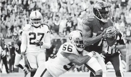  ?? KARL MERTON FERRON/BALTIMORE SUN ?? Wide receiver Mike Wallace catches a pass for a 2-point conversion in front of Raiders linebacker Daren Bates on Oct. 2. Wallace’s 35 receptions for 490 yards and three touchdowns have been a bright spot for the Ravens in the absence of Steve Smith Sr.