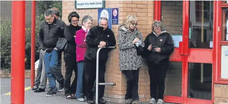  ?? Pictures: Mhairi Edwards/George McLuskie. ?? People waiting outside Broughty Ferry Health Centre before it opens.