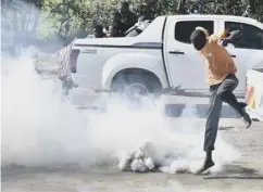  ??  ?? 0 Protesters flee from teargas fired by anti-riot police