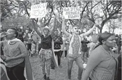  ?? AP Photo/Ben Curtis ?? Zimbabwean­s sing and pray at a Christian peace and prayer rally Sunday in downtown Harare, Zimbabwe. Zimbabwean­s around the country attended Sunday church services and peace rallies. A sign in Shona at right reads “It was Jesus who planned it”.