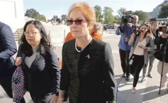  ?? CHIP SOMODEVILL­A/GETTY IMAGES ?? Former U.S. Ambassador to Ukraine Marie Yovanovitc­h (center) is surrounded by lawyers, aides and journalist­s as she arrives Friday at the U.S. Capitol.