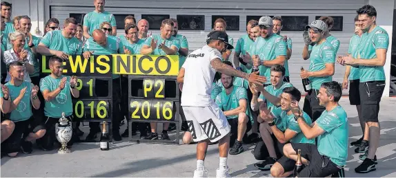  ??  ?? Con danza incluida, el británico festejó junto a los técnicos del equipo Mercedes. Ahora aventaja a su compañero de equipo Rosberg en el Mundial.