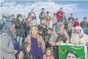  ??  ?? IN MOURNING: Residents gather to honour the militia fighter Muhammad Masiro, who was killed in Syria’s war, in Kobane, left.