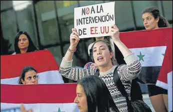  ?? AP ?? A protester in Chile displays a paper that reads in Spanish ‘No interventi­on of the US’ in Syria.